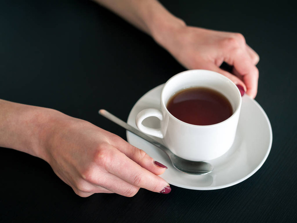 Morgen Tasse Tee in den Händen einer jungen Frau - Foto, Bild