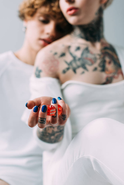 szelektív összpontosít, tetovált nő piros kocka közeli barátja elszigetelt szürke gazdaság - Fotó, kép