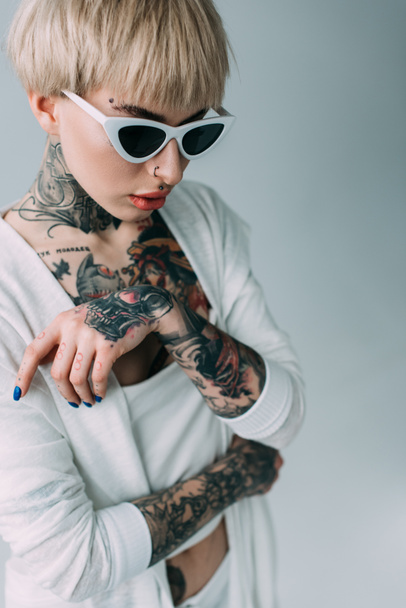 atraktivní žena s tetováním nosí sluneční brýle izolované Grey  - Fotografie, Obrázek