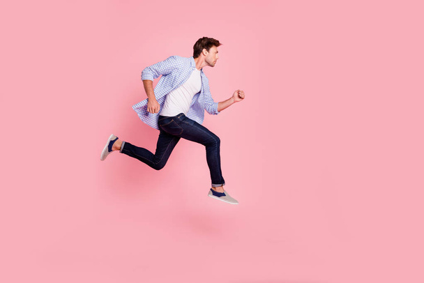 Full length side profile body size photo of jumping high he his him handsome run fast  look empty space need win victory winner wearing casual jeans checkered plaid shirt isolated on rose background - Φωτογραφία, εικόνα