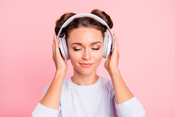 Close-up portrait of nice lovely sweet attractive calm peaceful conecnrated focused girl wearing touching earphones closed eyes isolated over pink pastel background - Fotoğraf, Görsel