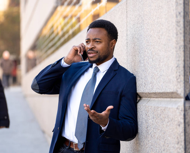 Attractive businessman talking on smart mobile phone in urban city street in happy people working outside. Social network, freedom, modern technology and Entrepreneur Creative Business concept. - Photo, image