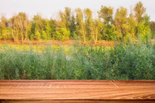 日没で川沿いの夏の背景で空の木製テーブル。表示やモンタージュの製品に使用することができます。 - 写真・画像