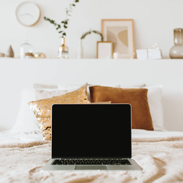 Relax, chill with laptop in bed with pillows. Apartment interior design concept. Freelancer, blogger composition. Blank mockup screen hero header for blog, website, social media. - Photo, Image