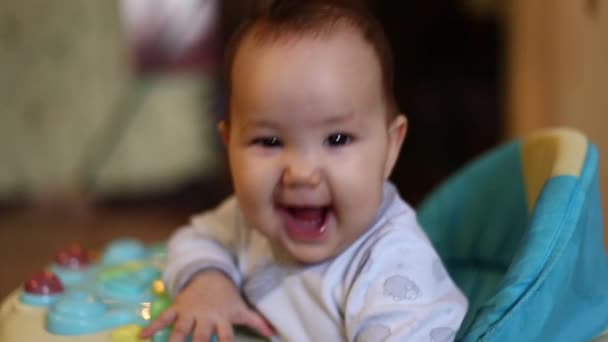 happy laughing baby girl asian in walker, smile in camera, selected focus, soft focus - Footage, Video