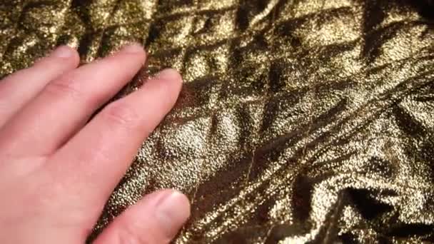 Człowiek, dotykając piękny złoty nylon materiał: poliester. - Materiał filmowy, wideo
