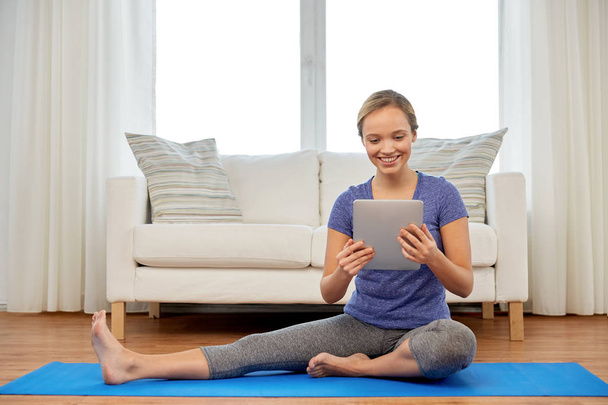 woman with tablet computer doing yoga at home - Fotografie, Obrázek
