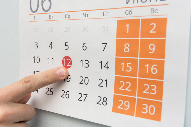 Palec wskazuje na wakacje w kalendarzu ściennym - Zdjęcie, obraz
