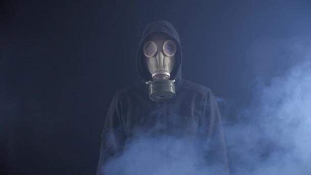 hombre acosador en una máscara de gas sobre un fondo negro que protege del humo
. - Imágenes, Vídeo