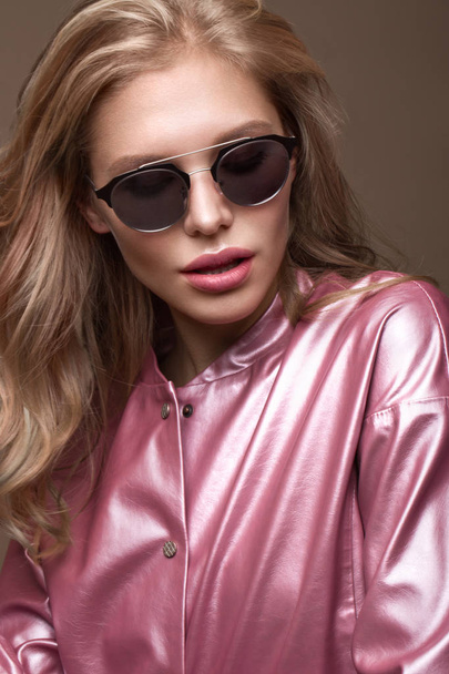 Beautiful girl in stylish pink clothes with sunglasses and sexy lips. - Foto, Imagen