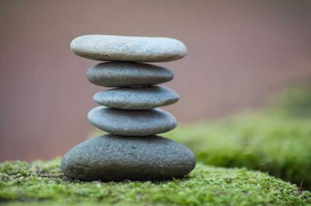 Closeup of stone balance on moss in the forest  - 写真・画像