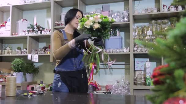 Цветочница в цветочном магазине работает с цветами и букетами
. - Кадры, видео