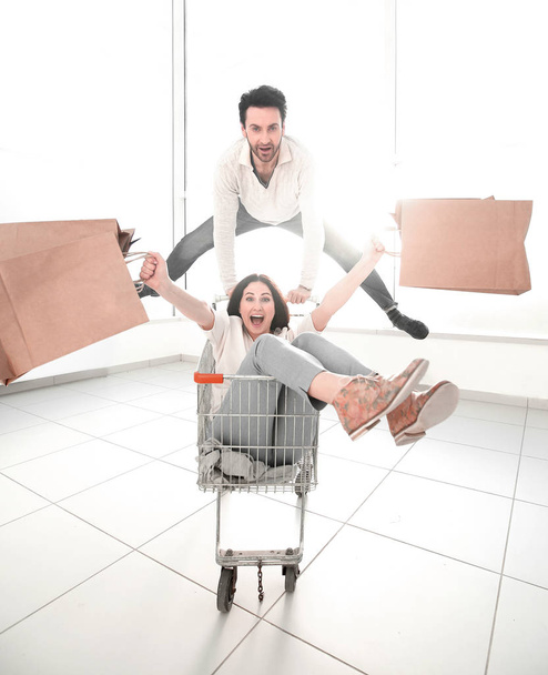 man carries his girlfriend in a shopping cart - Zdjęcie, obraz