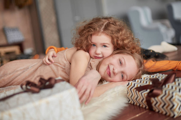 two pretty sisters are having fun in a cozy living room - Fotografie, Obrázek