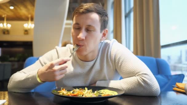 Atrakcyjny mężczyzna jedzenie Sałatka siedząc w kawiarni, Selektywny fokus - Materiał filmowy, wideo