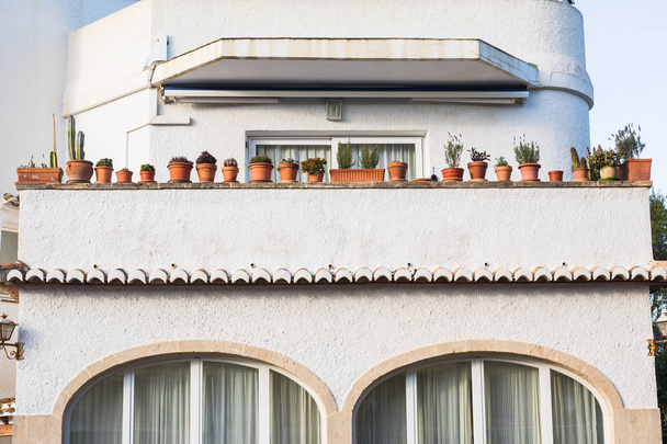 Façade avec balcons et beaucoup de pots de fleurs. Détail architectural
. - Photo, image