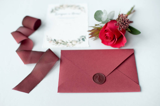 Wedding invitation as a decorated letter on a white tablecloth with a flower arrangement - Zdjęcie, obraz