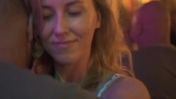 Happy couple embracing and dancing at night party in dance club. Beautiful woman hugging man while dancing at dance hall in restaurant. Couple lovers having fun together. - Záběry, video