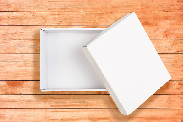 Opened white cardboard box on coral wooden background - Fotoğraf, Görsel