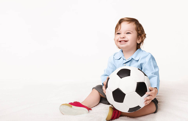Adorável menino sentado com bola de futebol
 - Foto, Imagem