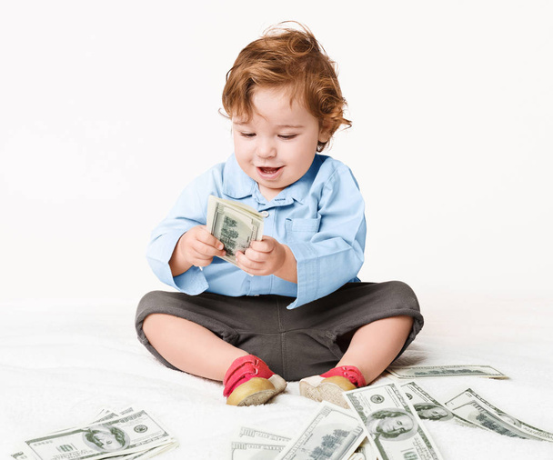 お金紙幣で床に座っている男の子の赤ちゃん - 写真・画像