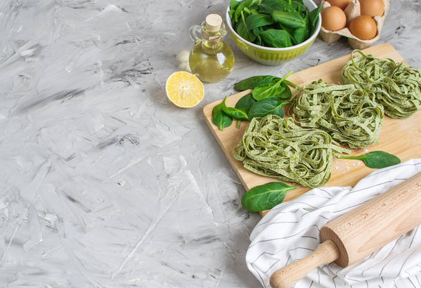 Підготовка італійський Raw домашнє зелений шпинат макарони Тальятелле приготування випічки кухні таблиці різні інгредієнти яйця оливкова олія борошна - Фото, зображення