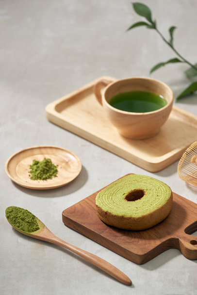 Green tea matcha in a wooden cup with German cake on the brown mat close-up - Fotoğraf, Görsel