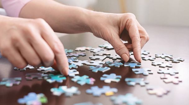 Elderly woman hands doing jigsaw puzzle closeup - Fotoğraf, Görsel