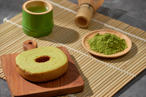 Matcha green tea latte in a cup and tea ceremony utensils with German cake. Copy space - Foto, Imagem