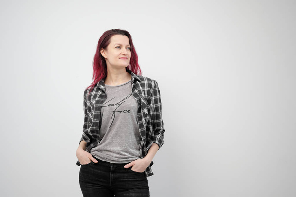 The girl in a plaid gray shirt on a white background with dyed red hair. - Foto, immagini