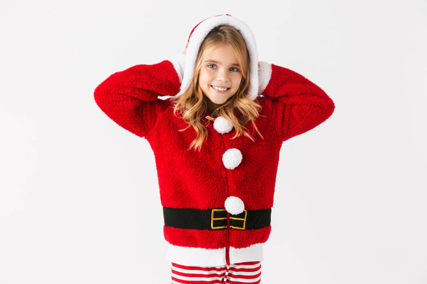 Cute cheerful little girl wearing Christmas costume isolated over red background - Photo, image