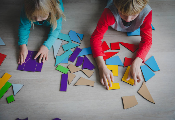 kids playing with puzzle or tangram, education and learning concept - Photo, image