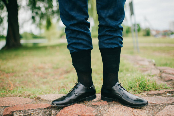 partial view of man in wedding suit standing outdoor with socks put on trousers - Fotó, kép