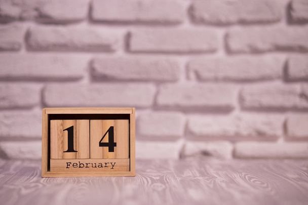 14 february set on wooden calendar with white brick background. - Фото, изображение