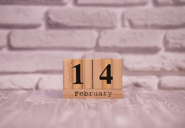 14 february set on wooden calendar with white brick background. - Foto, Bild