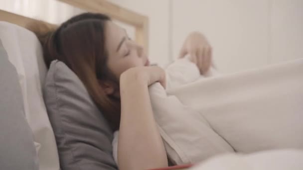 Krásná mladá asijská žena čte knihu vleže na posteli, Žena spát po odpočívat v pokoji doma. Životní styl žen užívajících uvolnit čas na domácí koncept. - Záběry, video