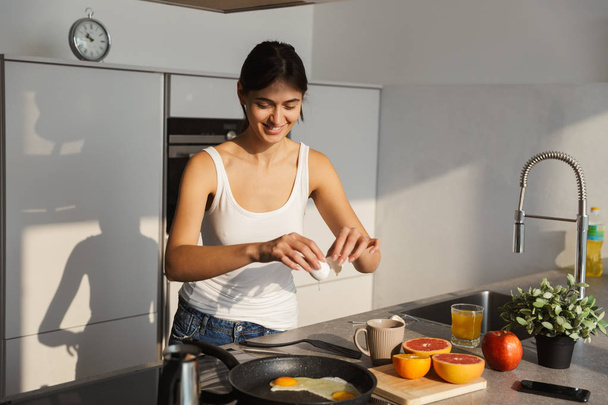 Image of an amazing happy healthy woman in the kitchen standing daily morning routine cooking breakfast. - Photo, image