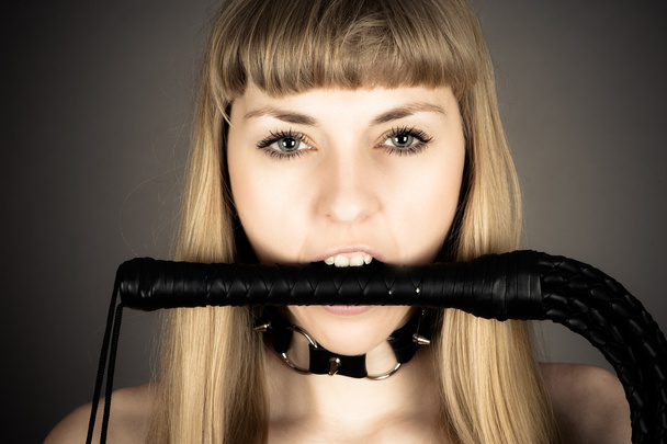 woman holding a whip in his mouth - Photo, Image