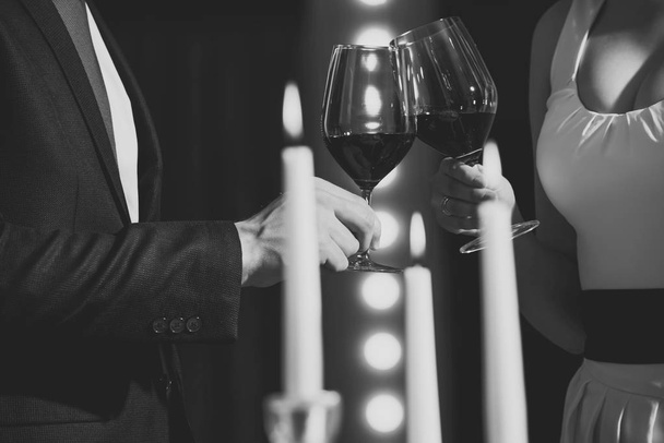 gli occhiali di battito di ciglia con vino rosso di coppia all'atto di incontro
 - Foto, immagini
