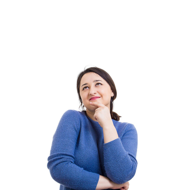 Mujer joven casual pensativa cogida de la mano bajo la barbilla mirando hacia arriba como soñando aislado sobre fondo blanco con espacio de copia
. - Foto, Imagen