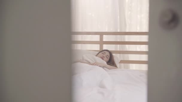 Beautiful attractive young Asian woman wake up, smiling and stretching her arms in her bed in the bedroom. Young asia female use relax time at home. Lifestyle women using relax time at home concept. - Filmmaterial, Video