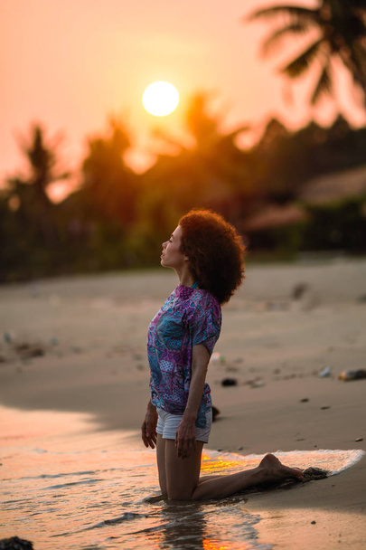 Mixed race woman on a tropical beach during amazing sunset. - Fotoğraf, Görsel
