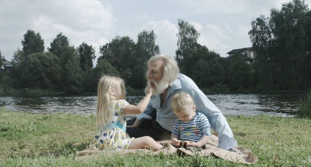 senior man with grandson and granddaughter bonding at nature - Photo, Image