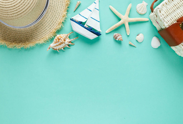 トロピック フラット横たわっていた麦藁帽子、バッグ、ヒトデ、貝、ボート、緑色の背景上のイヤリング。夏ファッション流行のフラットは、休暇旅行の概念を置きます。コピー スペース平面図.  - 写真・画像
