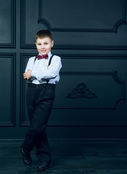 elegant boy wearing a white shirt and a bow tie in the interior - Foto, imagen