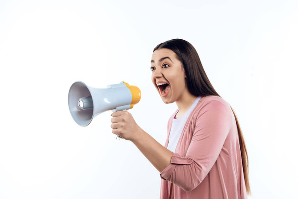 Young girl speaks into megaphone. Female activist. Isolated on white background. Studio portrait. Loud. Announcement - Photo, Image