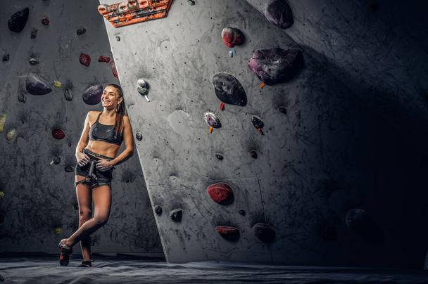 Sporty woman climbing artificial boulder indoors. - Photo, Image