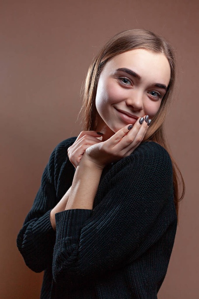 Beautiful young woman with a smile in a black sweater - Valokuva, kuva