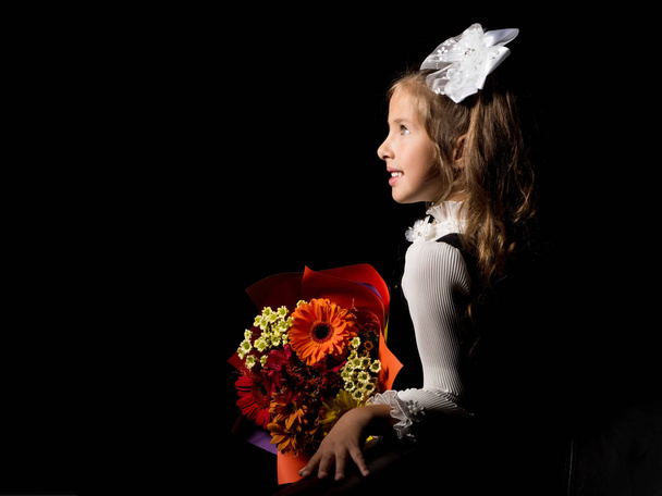 Meisje met een boeket bloemen op een zwarte achtergrond. - Foto, afbeelding