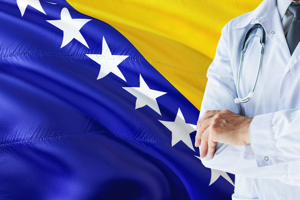 bosnischer Arzt, der mit Stethoskop vor dem Hintergrund der bosnisch-herzegowinischen Flagge steht. Konzept des nationalen Gesundheitssystems, medizinisches Thema. - Foto, Bild